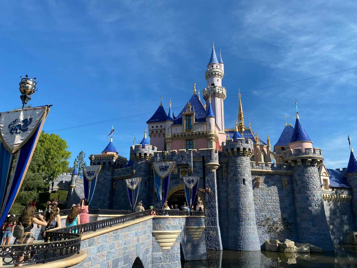 Visitors cross the bridge to Sleeping Beauty's Castle as Disneyland reopens its gates.
