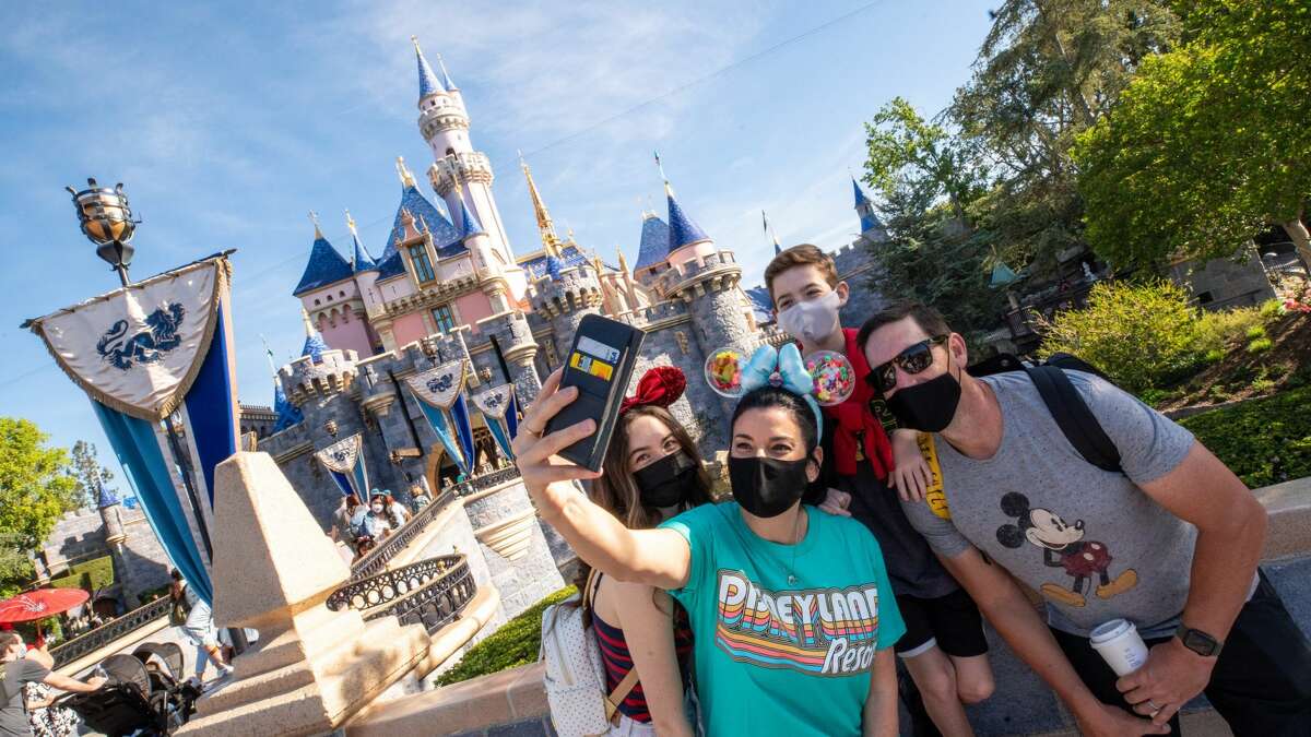 The Wotter family of Lake Elsinore, California, captures a special moment in front of Sleeping Beauty Castle as Disneyland Park in Anaheim, California, reopens on Friday, April 30, 2021.