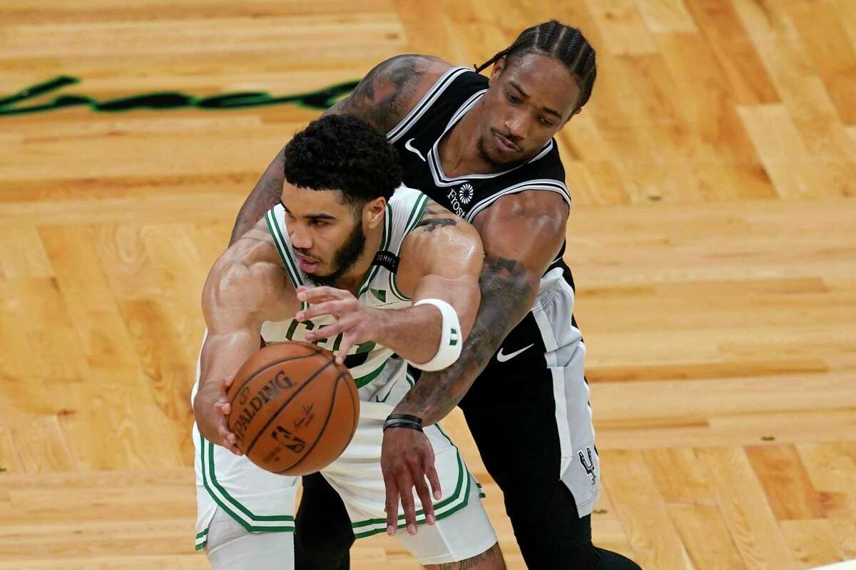San Antonio Spurs forward DeMar DeRozan reaches in to defend against Boston Celtics forward Jayson Tatum during the second half of an NBA basketball game Friday, April 30, 2021, in Boston. (AP Photo/Elise Amendola)