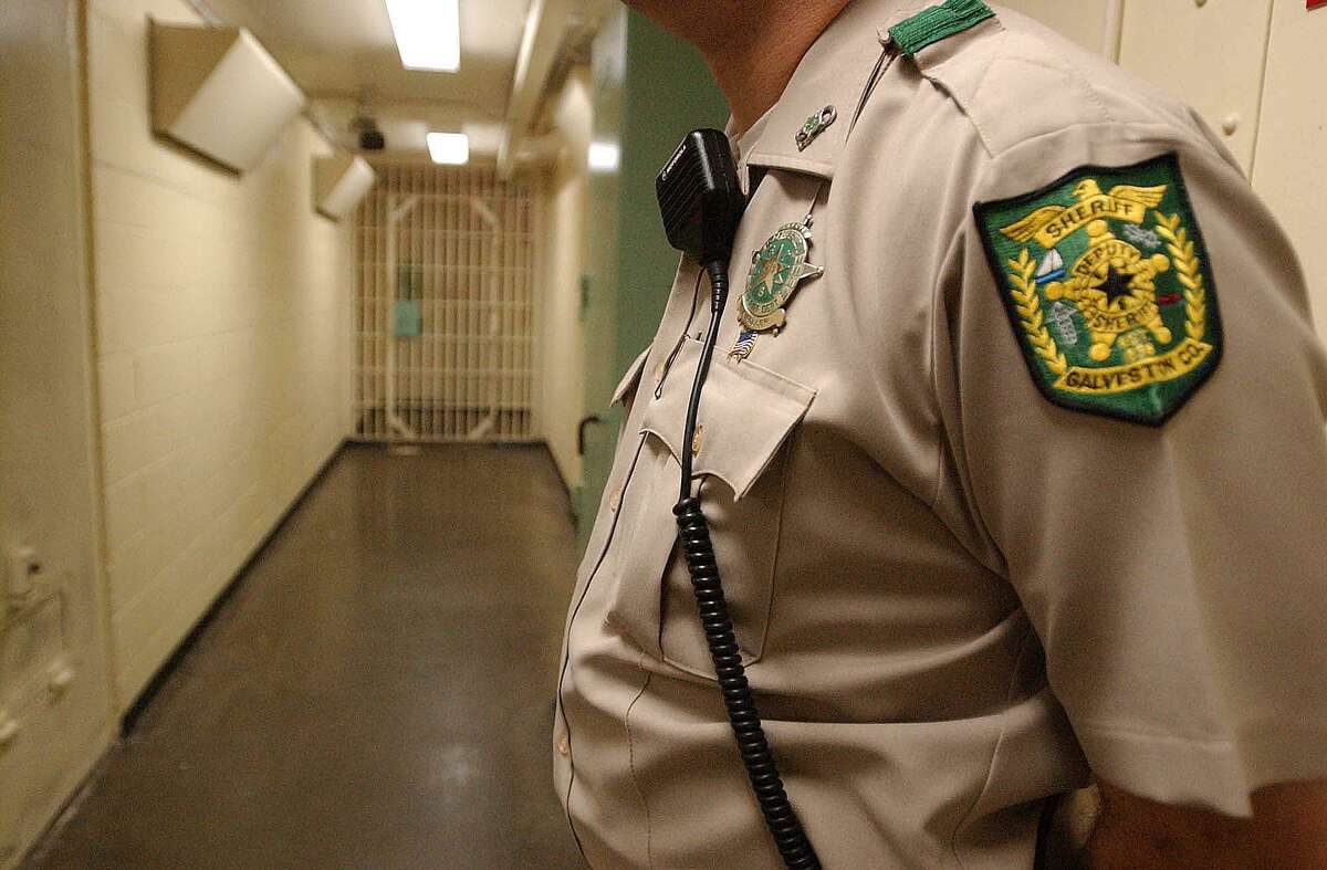 A file photo pictures a deputy standing guard with his radio attached to his collar at the Galveston County Jail.