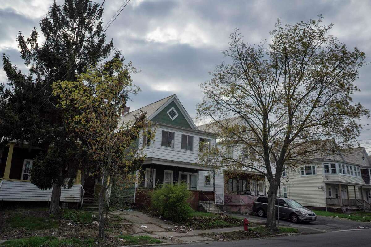 The house at 1042 Cutler Street, center, in Schenectady, N.Y., is pictured on April 20, 2021. The house is currently condemned and does not have heat, but the lower level tenant, Alfonzo Hill, is able to stay due to New York state's eviction moratorium.