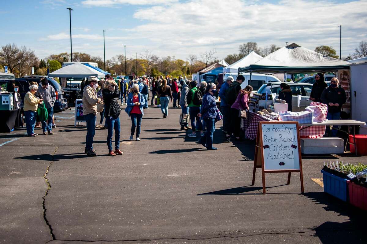 A crowd of people browse through vendors during opening day of the Midland Area Farmers Market, May 1, 2021.