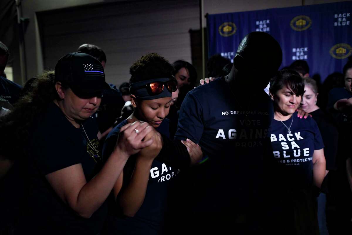 People pray after the defeat of Proposition B, the ballot initiative that would have repealed the police union’s right to collectively bargain, on May 1. 2021, election.