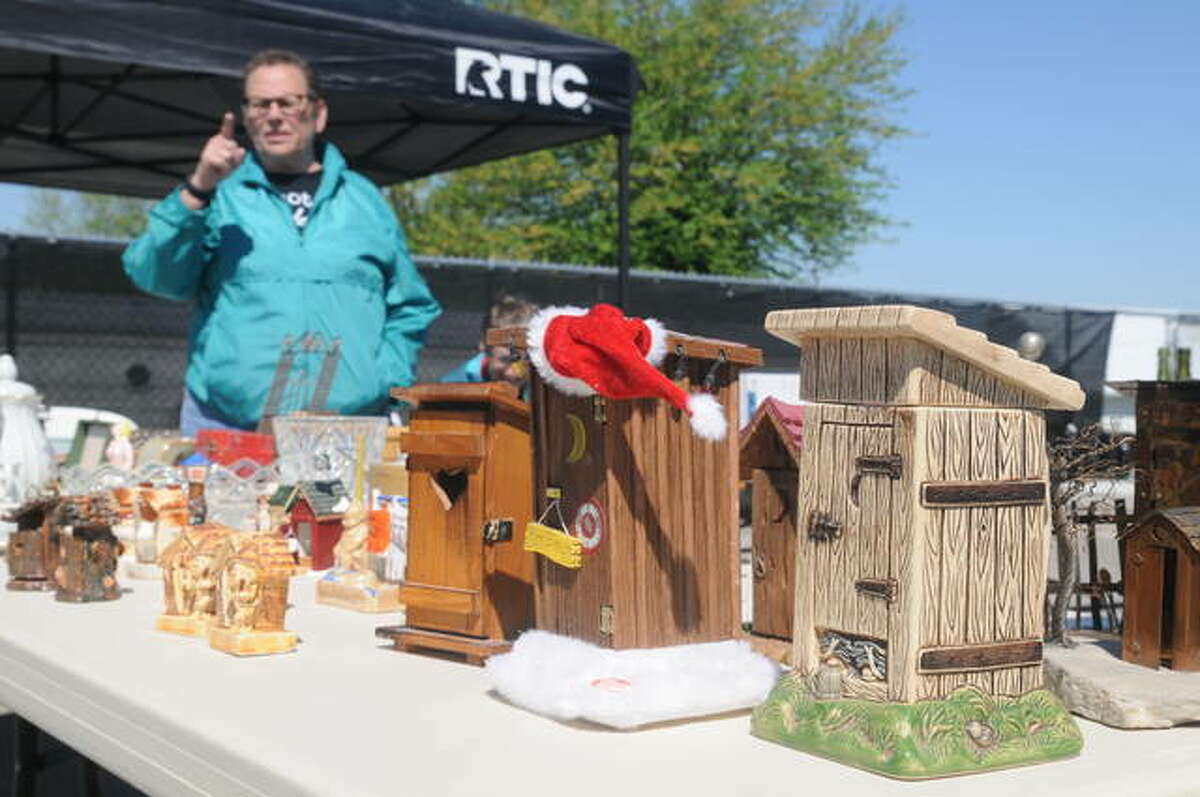 Janice Devening of Godfrey converses with a potential miniature outhouse buyer at her Dow flea market booth on Saturday, the start of the event’s inaugural season.