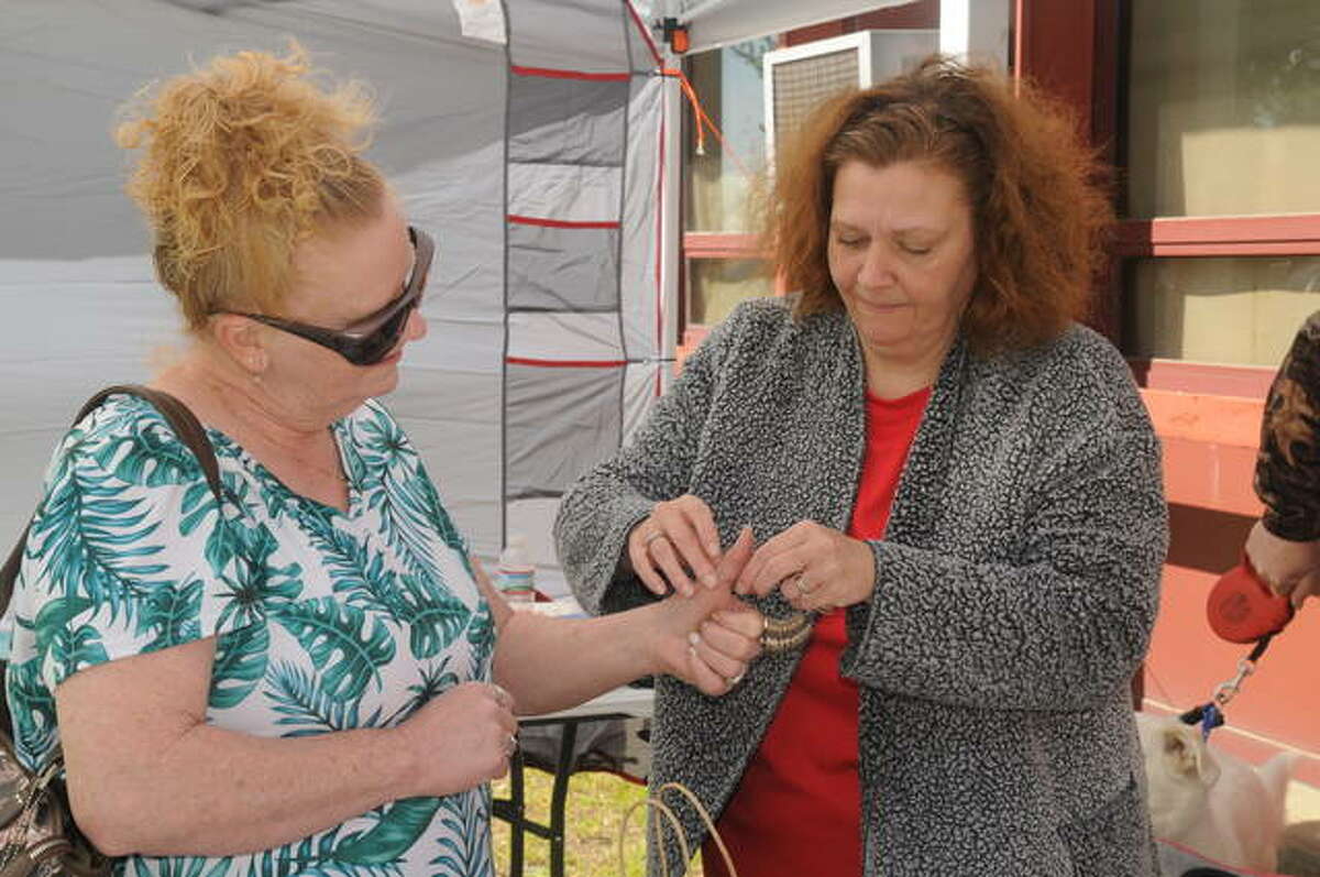 Debbie Handler of Nutwood gets measured for a ring by Dawn Sibley of Jerseyville during Saturday’s flea market in Dow.