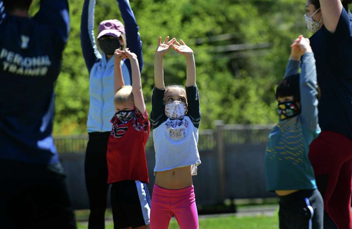 Children and parents including Valentina Delcampo, 7, center, participate in the Healthy Kids Day event at the New Canaan YMCA Saturday, May 1, 2021, in New Canaan, Conn. The event was full of fun activities that celebrate kids that included Family Fitness & Water Safety Demo, Family Bootcamp, Nine-Square in the air, Family Zumba, Vegetable seed planting and flower pot decorating.