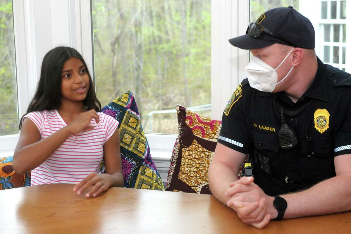 Teesa Arden, who is deaf, uses sign language to communicate with Trumbull Police Officer Derek Laaser, during an interview in Arden’s home in Trumbull, Conn. April 29, 2021.