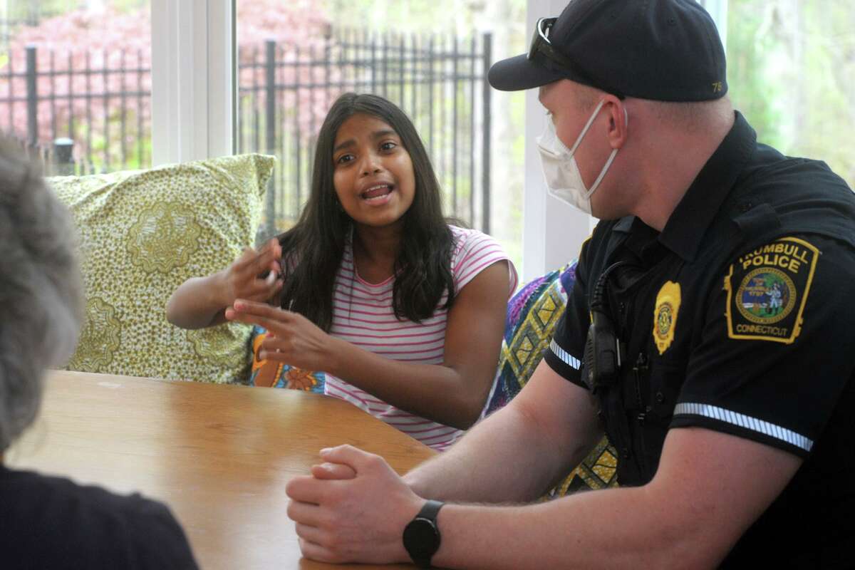 Teesa Arden, who is deaf, uses sign language to communicate with Trumbull Police Officer Derek Laaser, right, and Jill Angotta, left, her teacher for the deaf from the Trumbull schools during an interview in Arden’s home in Trumbull, Conn. April 29, 2021.