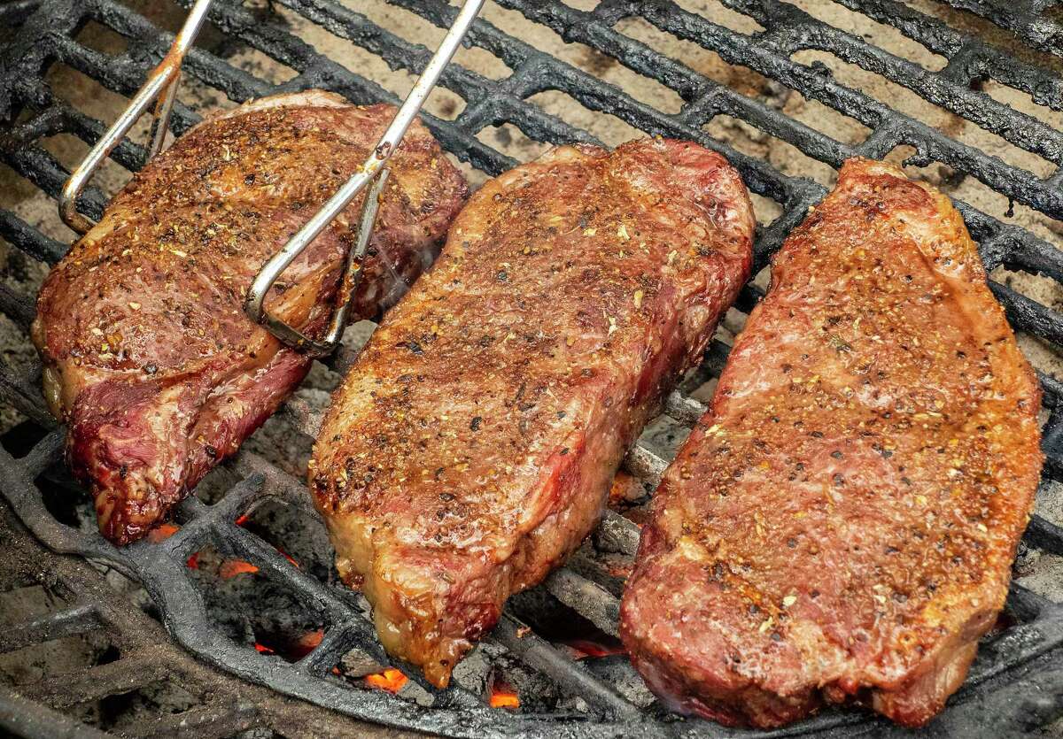 Steaks that have been cooked are placed on a grill to be reverse seared. It's all about exposing the steaks to low heat to cook to the proper internal temperature, then finishing them off hot on the grill.