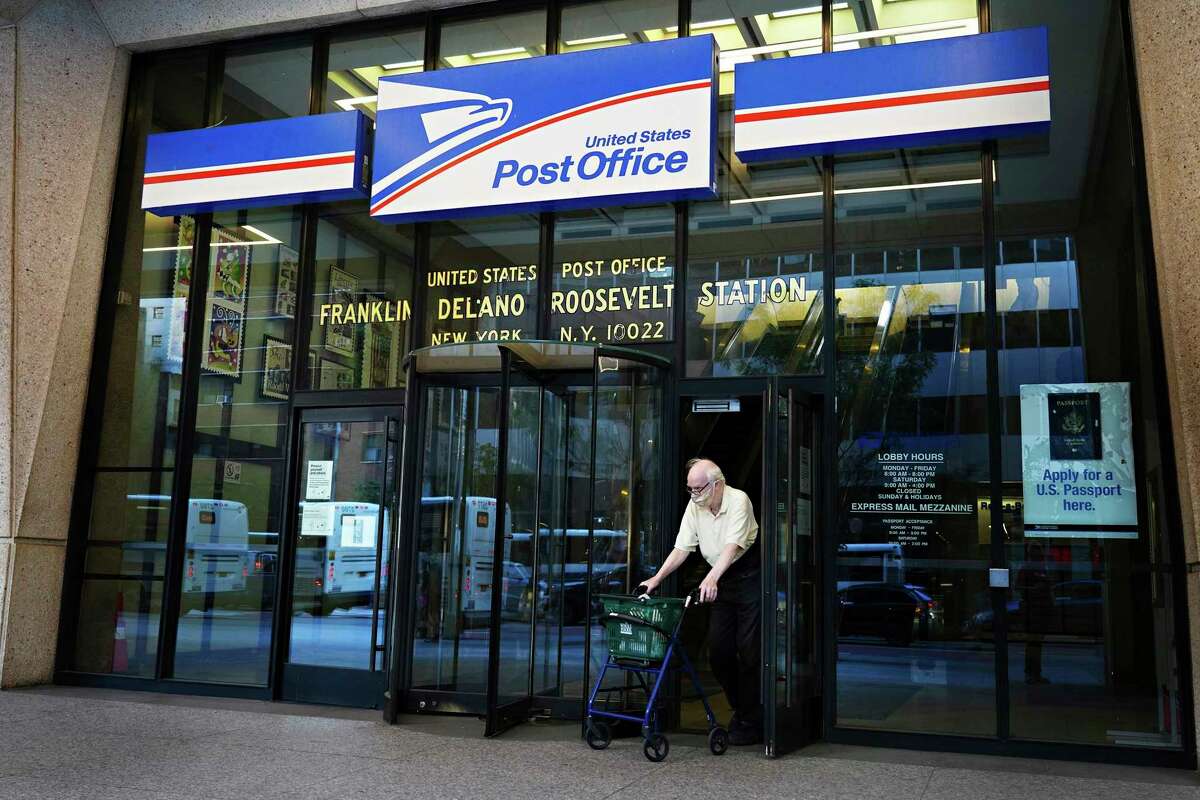 A man wearing a protective mask exits a U.S. Post Office in New York on August 18, 2020. (Cindy Ord/Getty Images/TNS)
