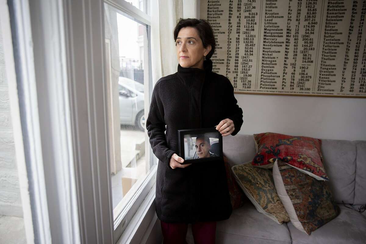 在旧金山的家中，维拉·阿瑞斯拿着她已故丈夫古斯塔沃·佩塞的照片。