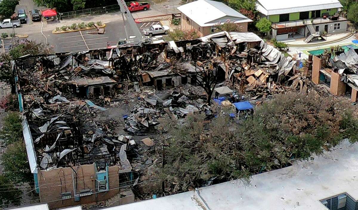 An aerial photograph shows the catastrophic damage caused by a deliberately set fire at Iconic Village Apartments near Texas State University in San Marcos. Five people were killed and another was severely injured. No one has been arrested for the crime.