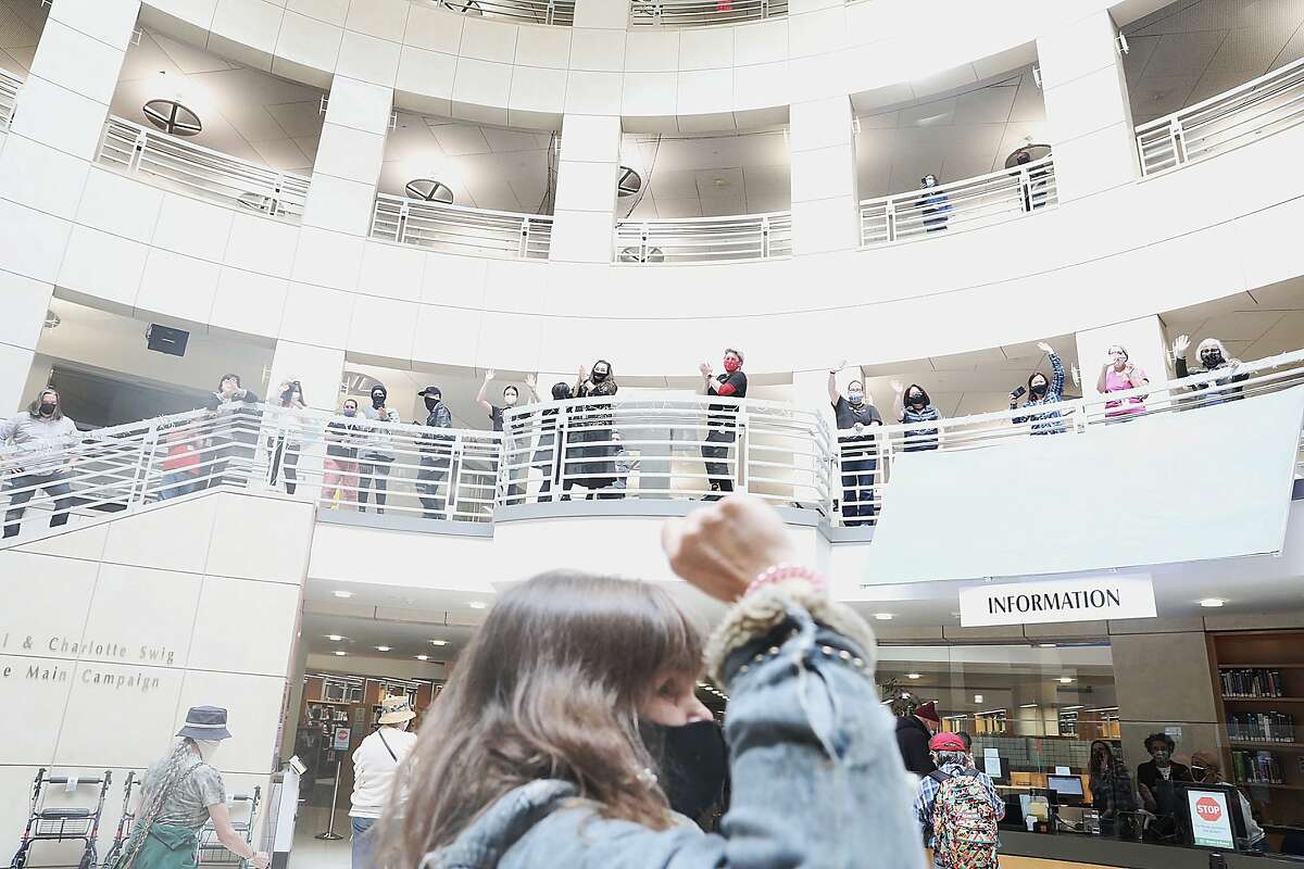 2021年5月3日，星期一，在加利福尼亚州旧金山，莫妮卡·格罗夫(中)等人自2020年3月以来首次进入主图书馆，图书馆工作人员鼓掌欢呼。