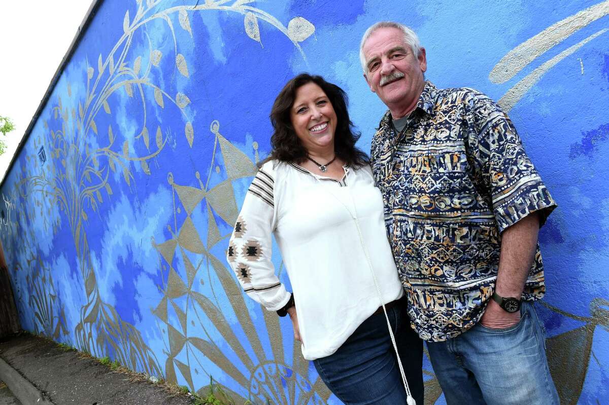 Gloria and Richard Krouch, owners of Bohemian High, by a mural on the side of their store on Bridgeport Avenue in Milford on May 4, 2021.