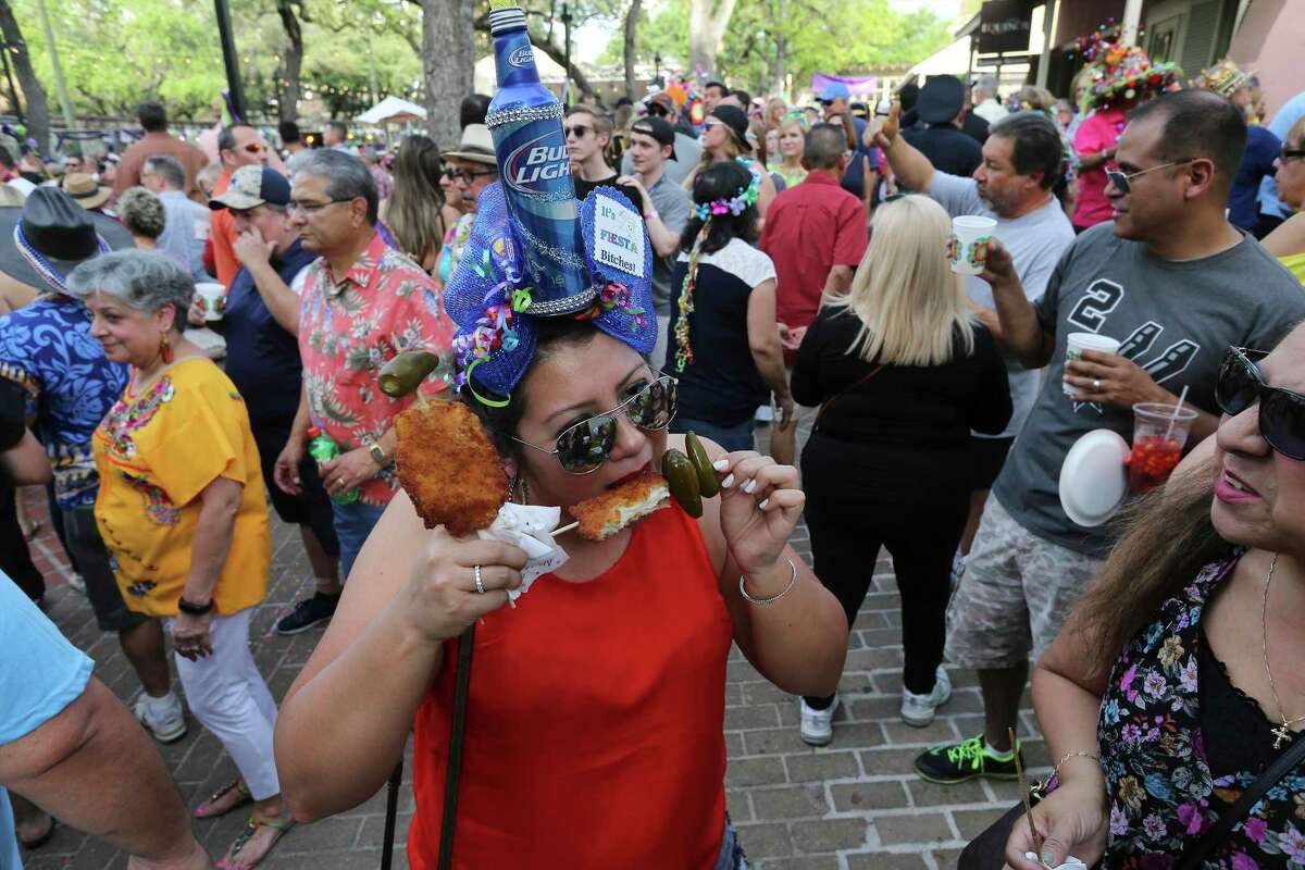 Raquel Rother takes a bite of her chicken on a stick at A Night in Old San Antonio in 2018. NIOSA this year will be held June 22-25.