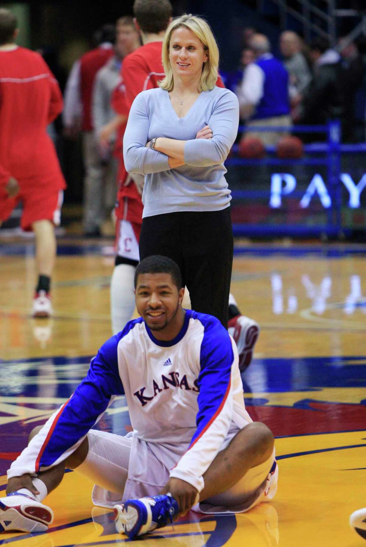 In this Jan. 8, 2010 file photo, Kansas strength coach Andrea Hudy stands behind a Kansas basketball player as they warm up for an NCAA college basketball game against Cornell in Lawrence, Kan. Hudy was named director of sports performance for UConn women's basketball on Wednesday.