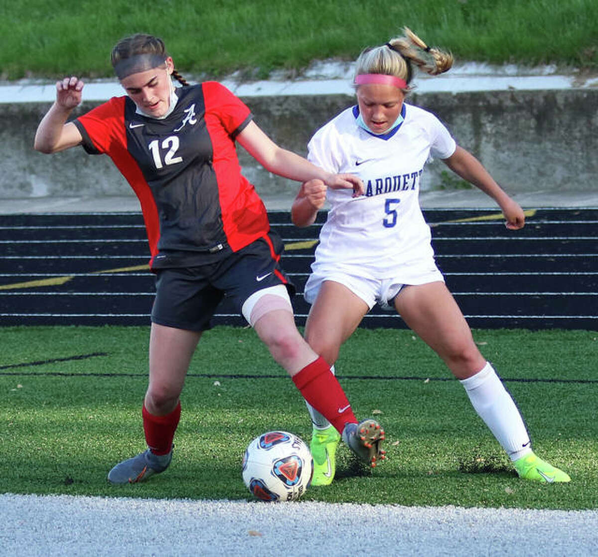 Marquette's Clare Antrainer (5) and Alton's Ainsley Redman battle for possession of the ball deep in Alton's end in the first half Wednesday at Public School Stadium in Alton.