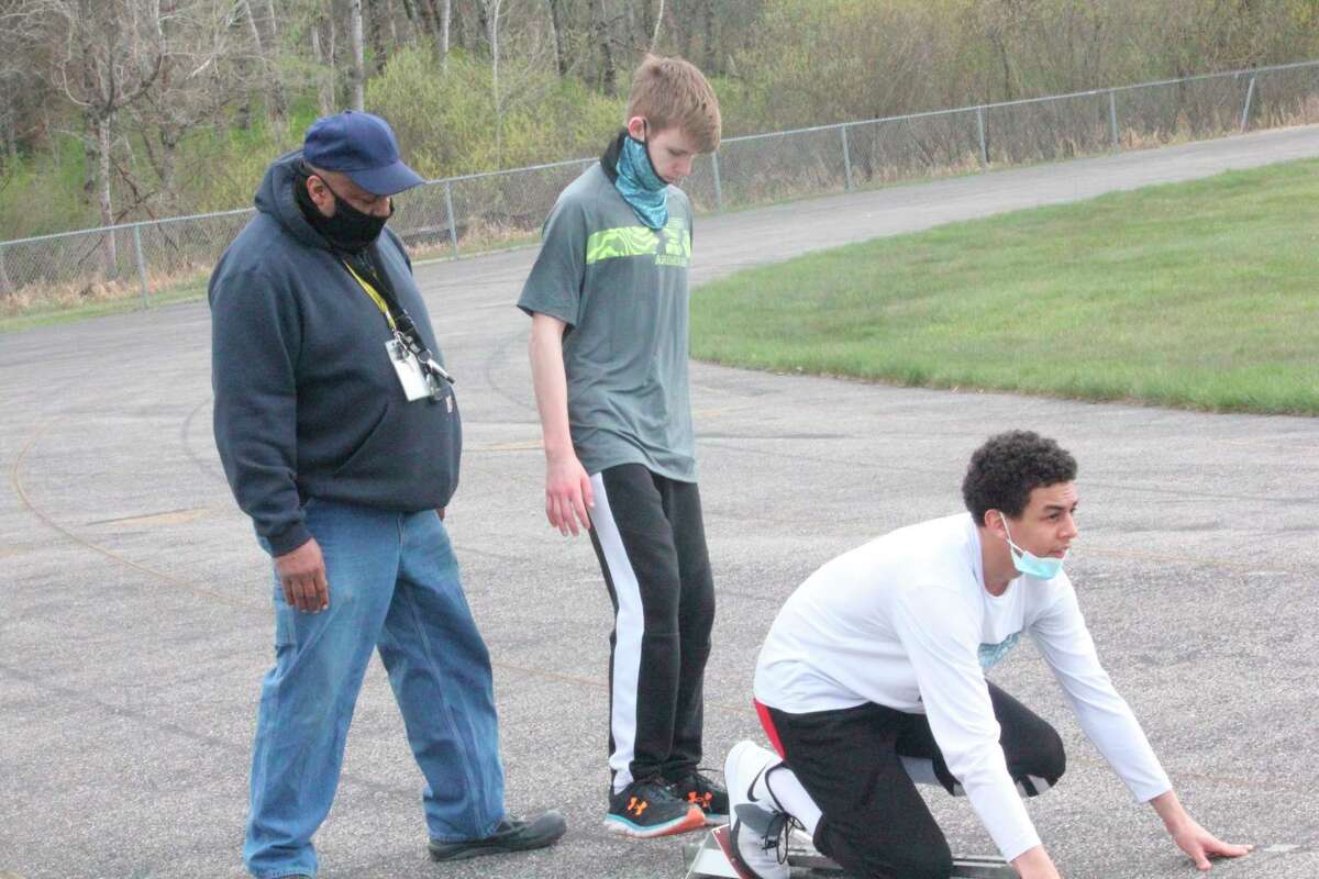 Baldwin boys track coach Bob Watkins (left) works with Jacob Cutler (center) and Anthony Austin on the track during a practice last week. (Star photo/John Raffel)