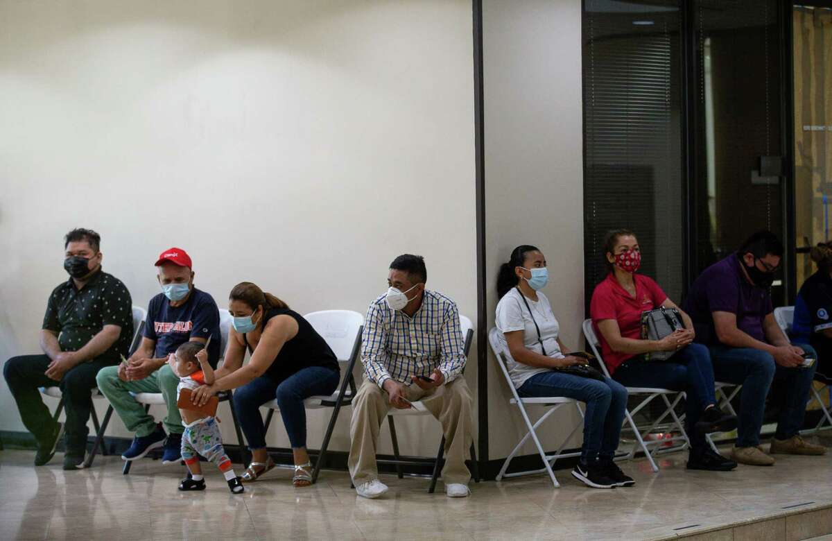 People wait to get Moderna’s COVID-19 vaccine at the Consulado General de El Salvador in southwest Houston on Thursday.