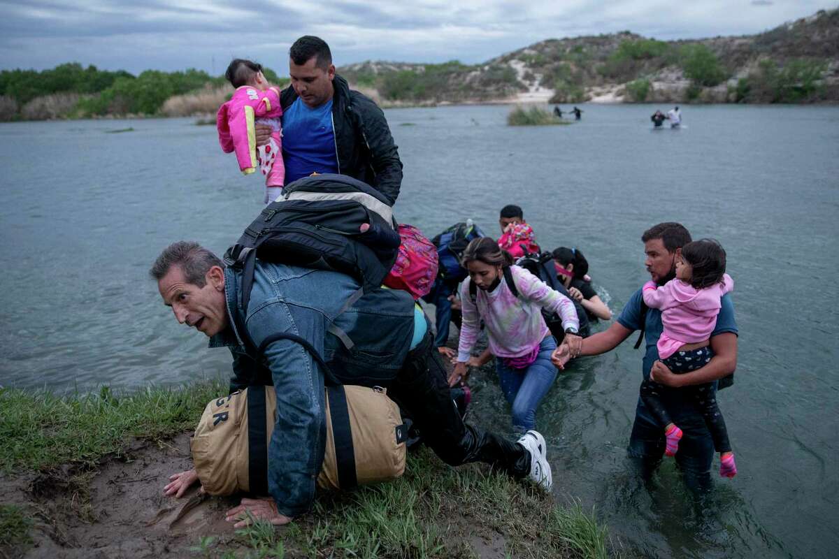A large group of migrants from Venezuela cross the Rio Grande near Del Rio. The U.S. has granted Venezuelans already in the country temporary protection from deportations because of the economic collapse and violence in their country.