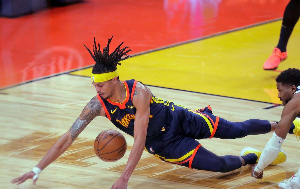 Damion Lee (1) dives for aloose ball in the second half as the Golden State Warriors played the Minnesota Timberwolves at Chase Center in San Francisco, Calif., on Monday, January 25, 2021.