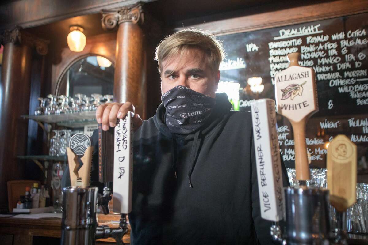 Owner Tom Madonna poses for a photograph behind the bar at Shotwell's Saloon in San Francisco on May 6, 2021. Patrons were able to drink indoors at a bar for the first time since the start of the COVID-19 shutdowns in March 2020.