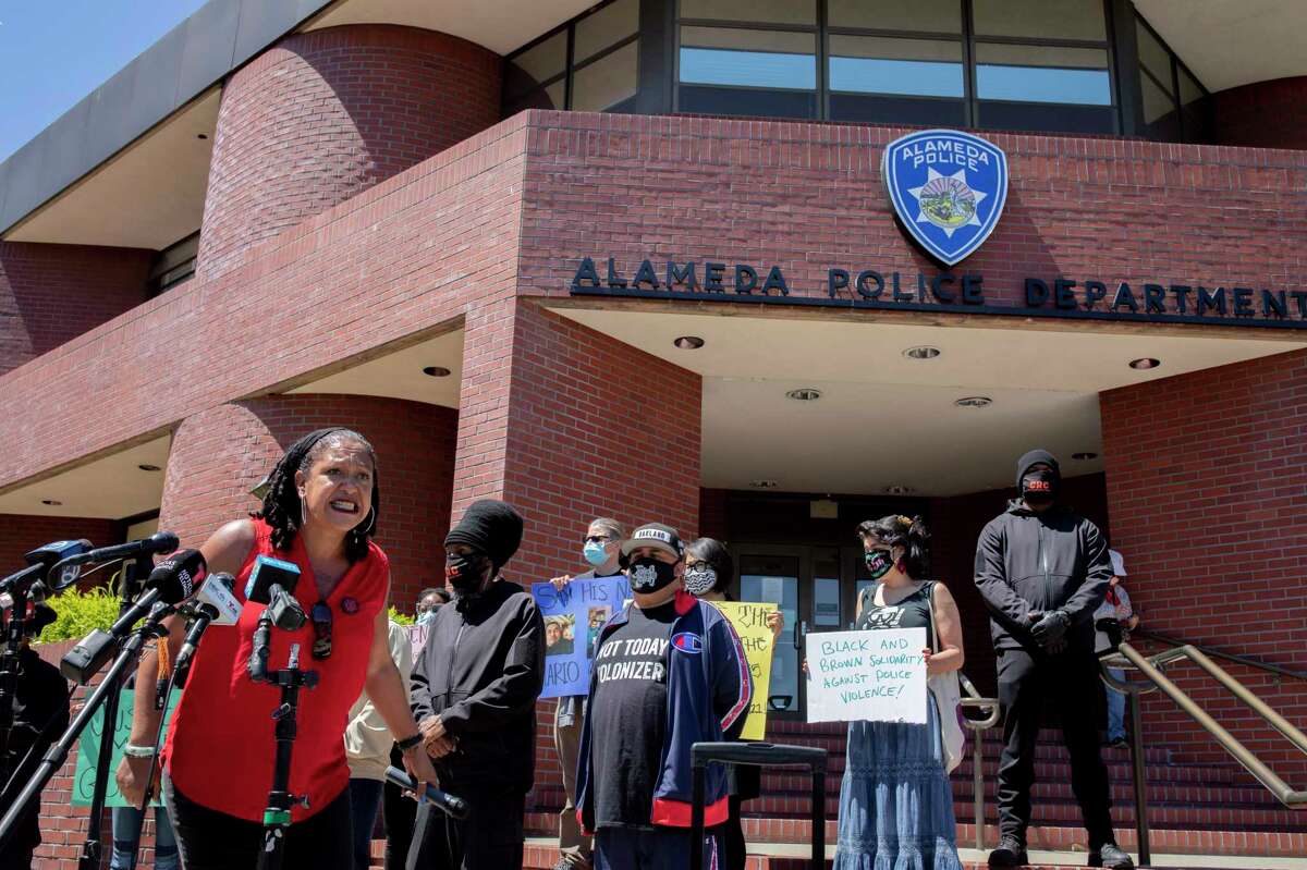 Cat Brooks, with the Justice Teams Network, rallies crowd to say Mario Gonzalez’s name at Alameda Police Department.