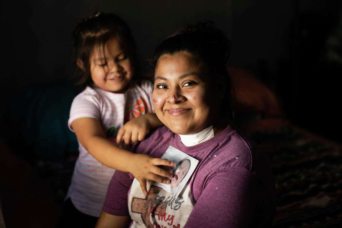 Maliyah Rodriquez, 4, (CQ) places a photo of her baby brother Cash Cockerham on her mother Dalia Avalos’, 24, heart, Friday, May 7, 2021, in Caldwell. They are both eager for his arrival home from the hospital after he finishes his treatment. Cash was born earlier than expected while Avalos was unconscious intubated battling COVID-19.