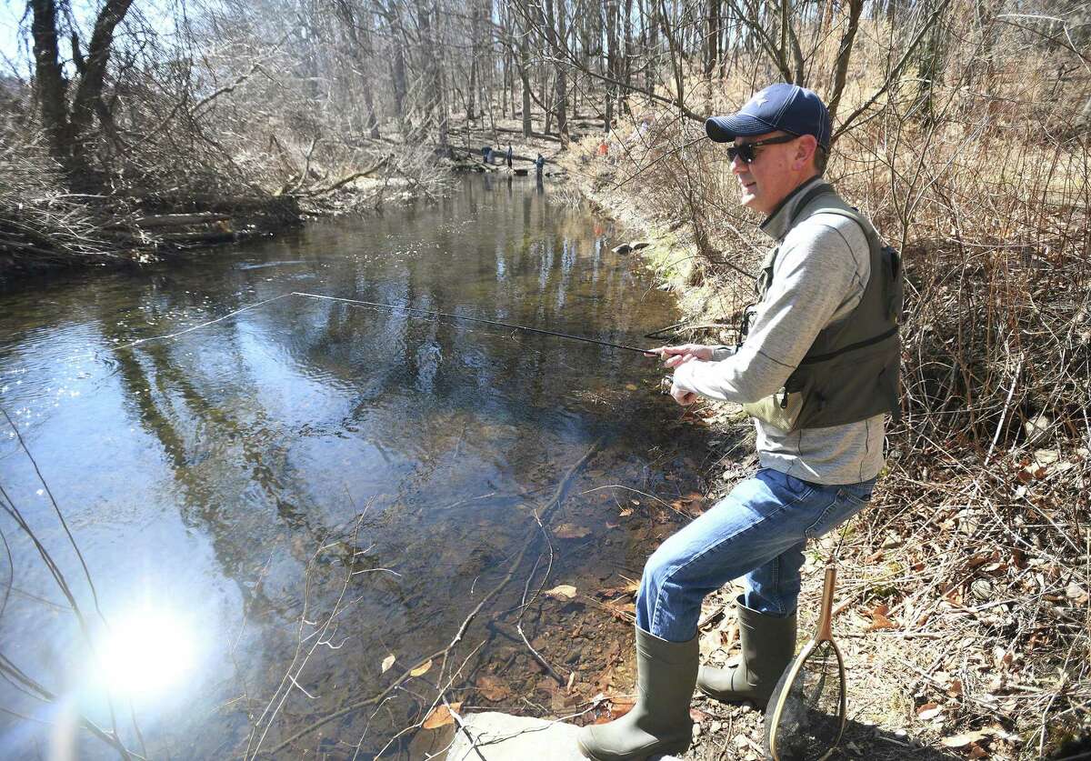 A fisherman tries out a new fishing spot on the Mill River in Fairfield on Sunday, March 21, 2021.