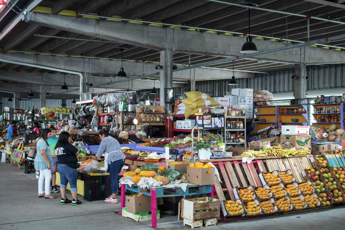 Shoppers browse items for sale at The Houston Farmer's Market Monday, May 3, 2021 in Houston. Construction on the revamped site is finished and vendors have begun moving in. The location will also include restaurants and a green space next to the market. The pillars in the area are from a former highway project by TXDOT.