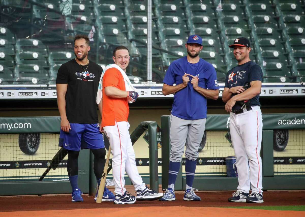 Former Houston Astros outfielder and current Toronto Blue Jays outfielder, on the IL, George Springer, from left, Houston Astros third baseman Alex Bregman (2), Toronto Blue Jays relief pitcher Tim Mayza (58) and Houston Astros relief pitcher Joe Smith (38) watch Houston Astros batting practice before an MLB game against the Toronto Blue Jays on Friday, May 7, 2021, at Minute Maid Park in Houston.
