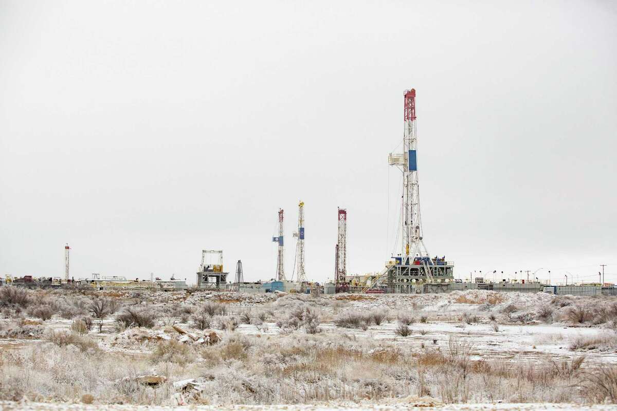 Drilling rigs are seen in a icy landscape in the Permian Basin during frigid weather. 