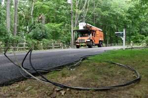 Crews examine downed trees and power lines knocked down during Tropical Storm Isaias on Deep Valley Road in North Stamford, Conn. Wednesday, Aug. 12, 2020.