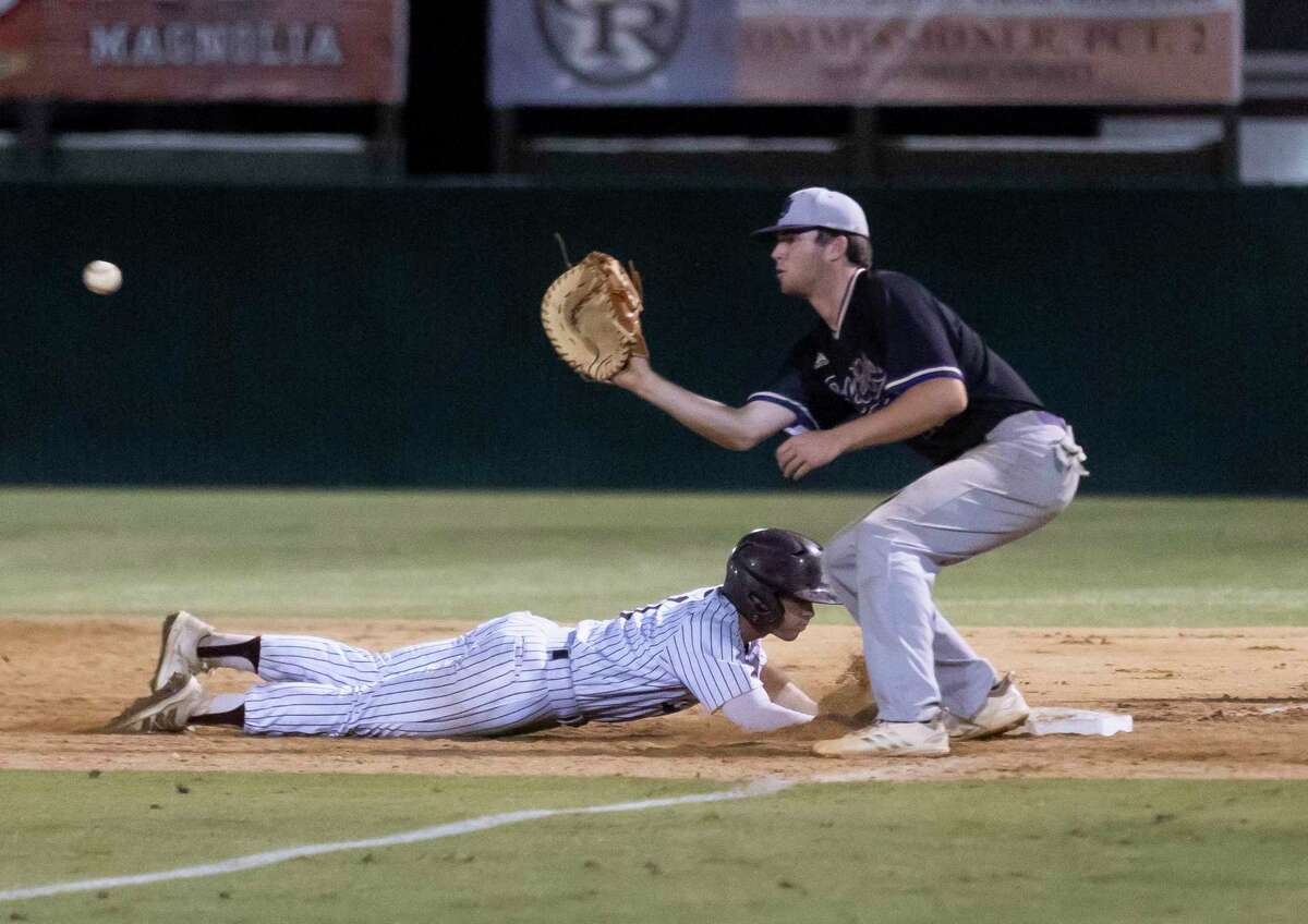 Tyler Middleton #1 of Magnolia dives toward first base before Montgomery first baseman Chase Davis (25) catches a throw during the sixth inning in Game 1 of the Region III-5A bi-district baseball series at Magnolia High School, Thursday, May 6, 2021, in Magnolia.