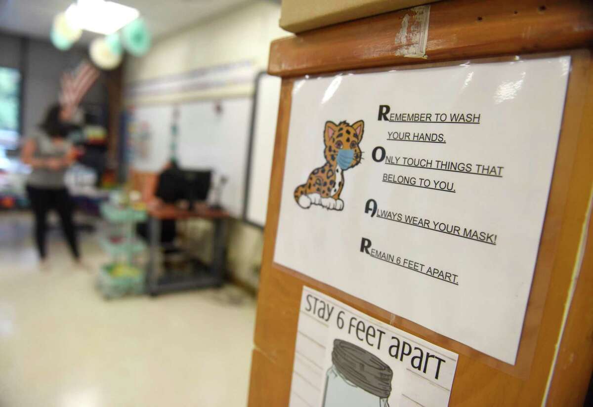 Signs urge students to practice safe hygenic habits to prevent the coronavirus spread at Springdale Elementary School in Stamford, Conn. Tuesday, Sept. 1, 2020. School districts are now deciding whether to offer remote learning in the 2021-22 school year.