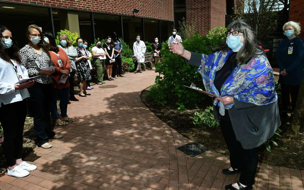 The Reverend Debra Slade leads the ceremony as Norwalk Hosptal staff gather for a dedication of the newly planted courtyard and the garden Friday, May 7, 2021, in Norwalk, Conn. The courtyard garden was dedicated to the hospital staff who worked during the height of the pandemic. Three new trees, 10 shrubs and 10 perrenial flowers were planted.