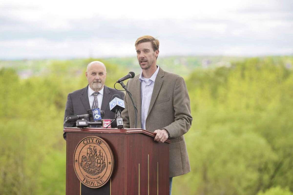 Troy Mayor Patrick Madden, left, looks on as Chris Wheland, superintendent for the City of Troy Department of Public Utilities, speaks during a ground breaking ceremony for a water infrastructure project on Monday, May 10, 2021, in Troy, N.Y. The project, which will take multiple years, is being done to replace the water transmission lines that connect the city's Tomhannock Reservoir to the water treatment plant. (Paul Buckowski/Times Union)