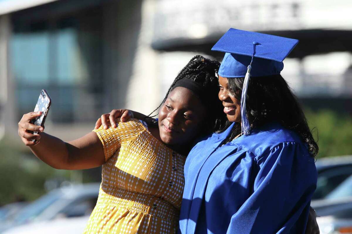 Jolanda Mitchell, 41, takes a photo with her daughter, Marley, 12, before the start of the St. Philip’s College Spring 2021 Drive In Graduation Ceremony at the AT&T Center parking lot last Thursday.