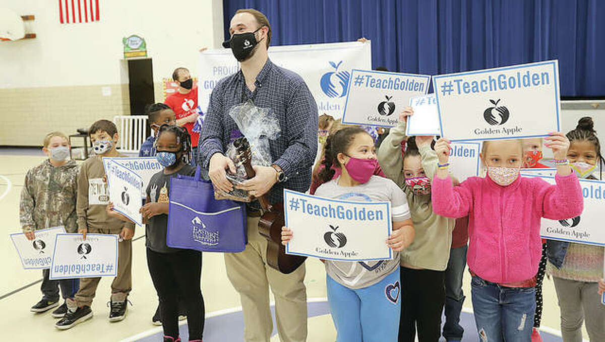 Lovejoy Elementary School music teacher Zebulon Holder poses for a picture with some of his students Monday after he was announced as a Golden Apple Award winner for Excellence in Teaching.