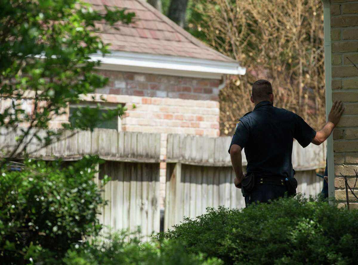 Law enforcement officials investigate the house where a tiger, which was loose last night on the 1100 block of Ivy Wall Drive, was being kept on Monday, May 10, 2021, in Houston.