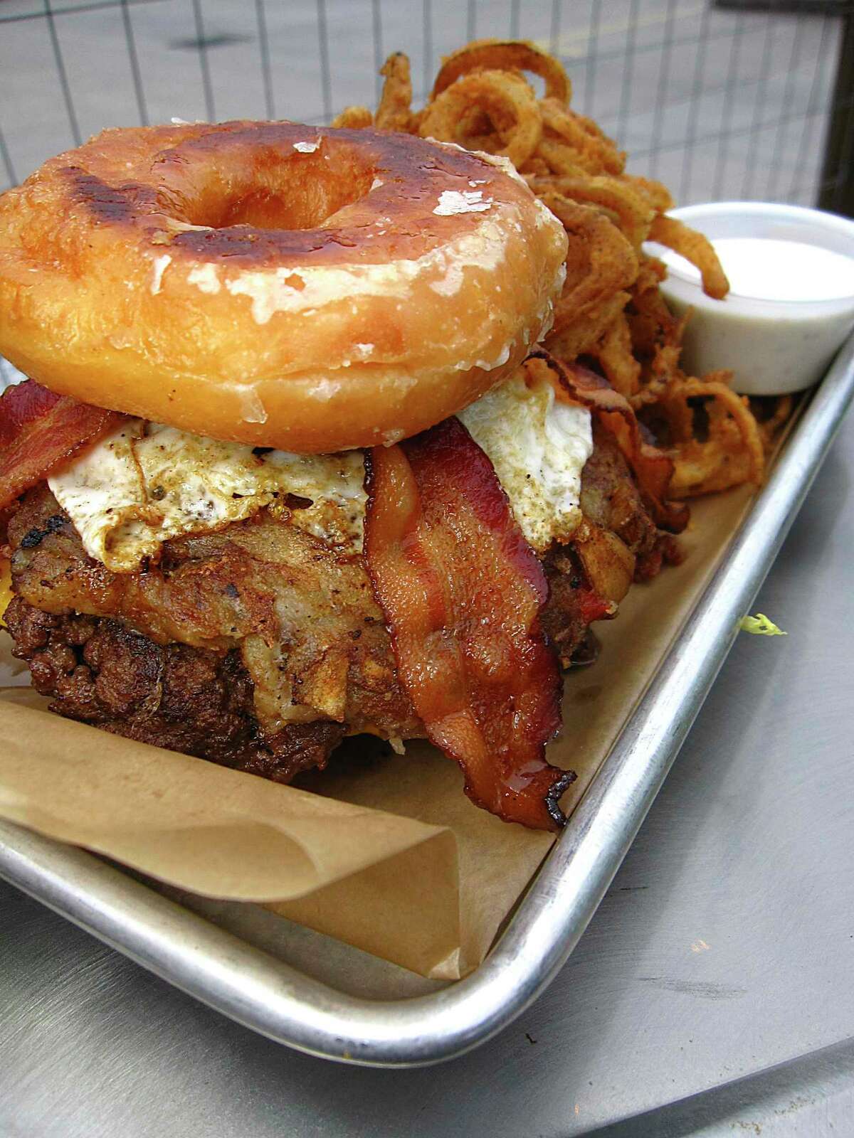 The Krispy Kreme Brunch Burger is two beef patties with hashbrowns, a fried egg, bacon and American cheese between two Krispy Kreme doughnuts at Lucy Cooper's Ice House
