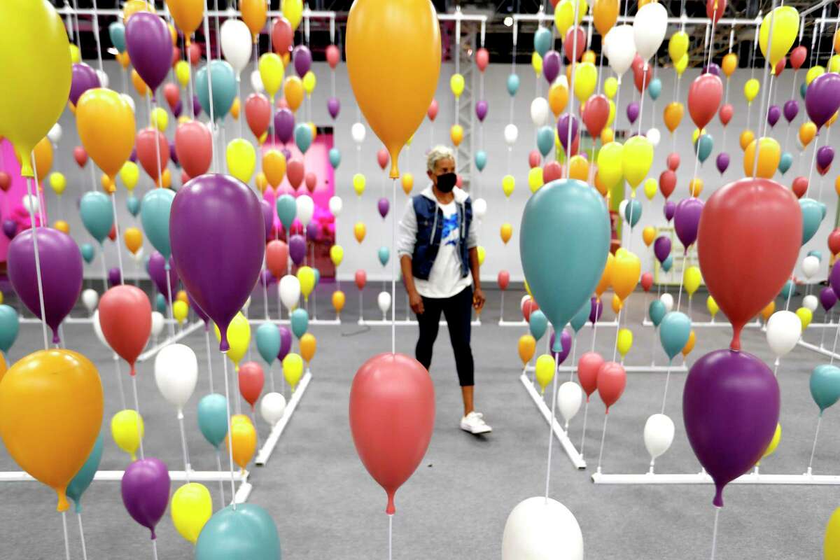 Renee Froix, a producer, walks through balloons in the maze in the “Oh, the Places You'll Go!” room inside the interactive The Dr. Seuss Experience - The Wondrous World of Dr Seuss at the George R. Brown Convention Center, Monday, May 10, 2021, in Houston.