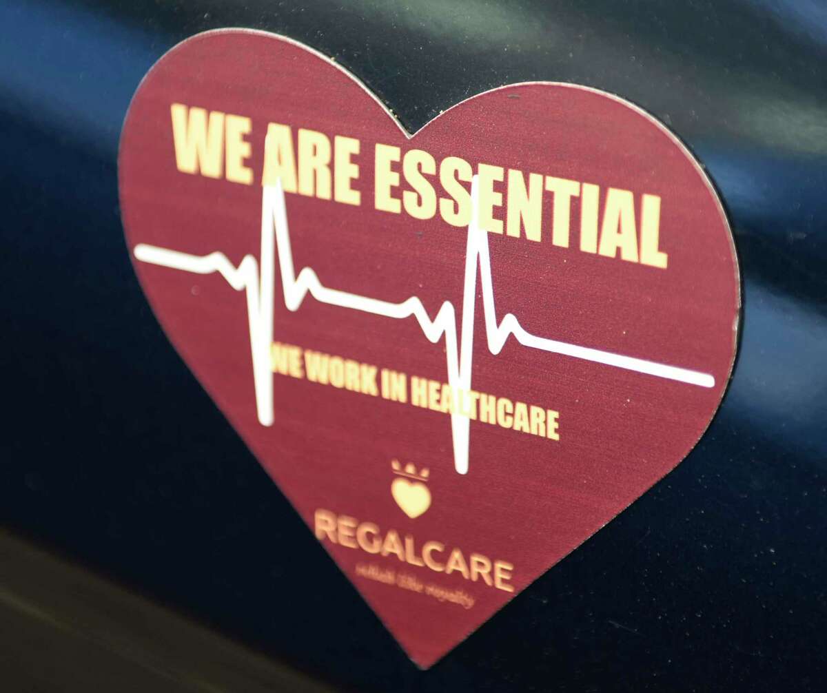 A magnet is displayed on a car parked at RegalCare nursing and rehabilitation center in Greenwich, Conn. Tuesday, May 11, 2021. Connecticut Gov. Ned Lamont has asked the head of the Connecticut National Guard to put 50 troops on standby to help oversee the 33 facilities that would be affected by 3,400 nursing home workers walking off the job Friday morning.