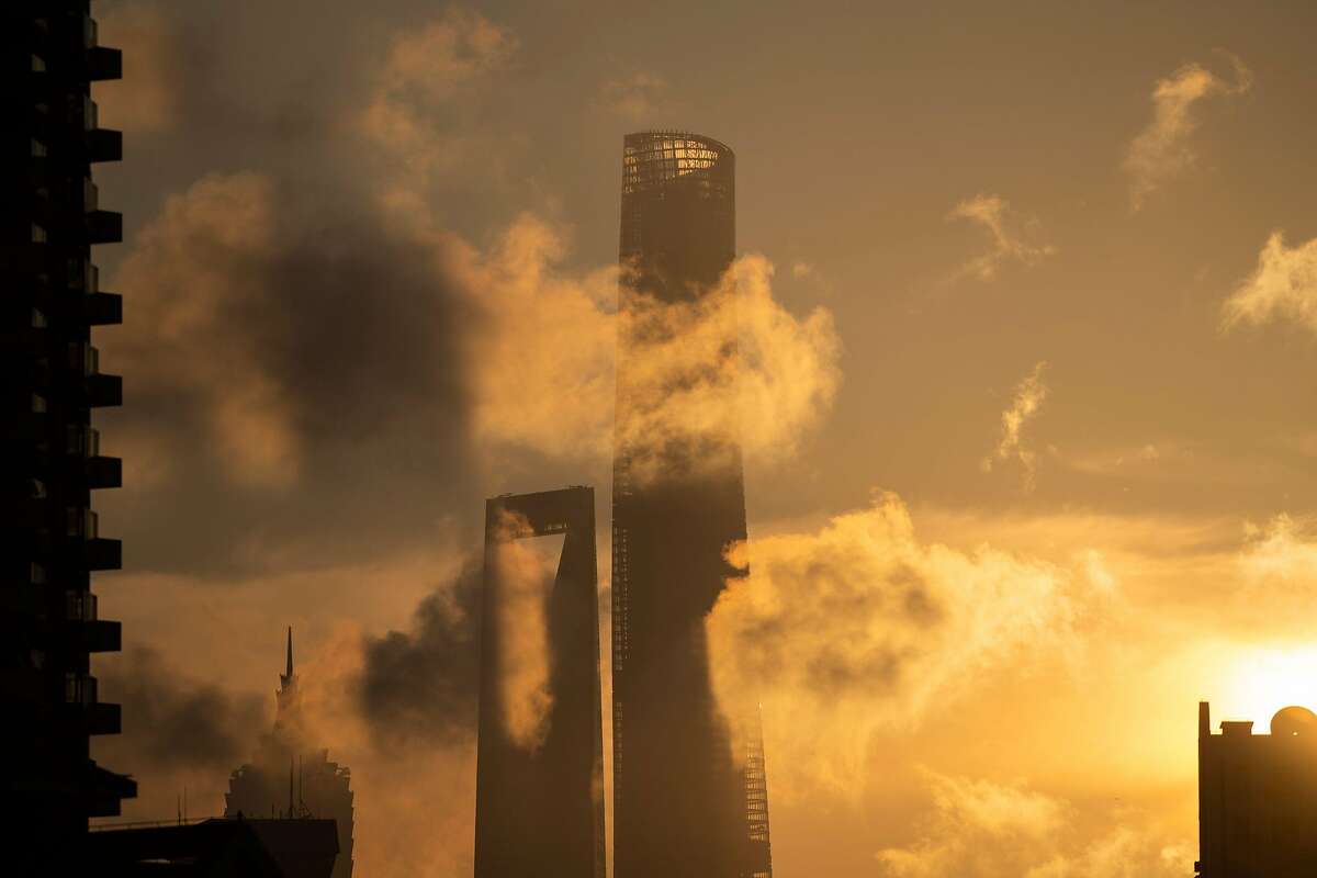 The sun rises behind the Jin Mao Tower (L), Shanghai World Financial Center (C) and the Shanghai Tower (R) in the financial district of Pudong in Shanghai on August 22, 2018. (Photo by Johannes EISELE / AFP) (Photo credit should read JOHANNES EISELE/AFP via Getty Images)