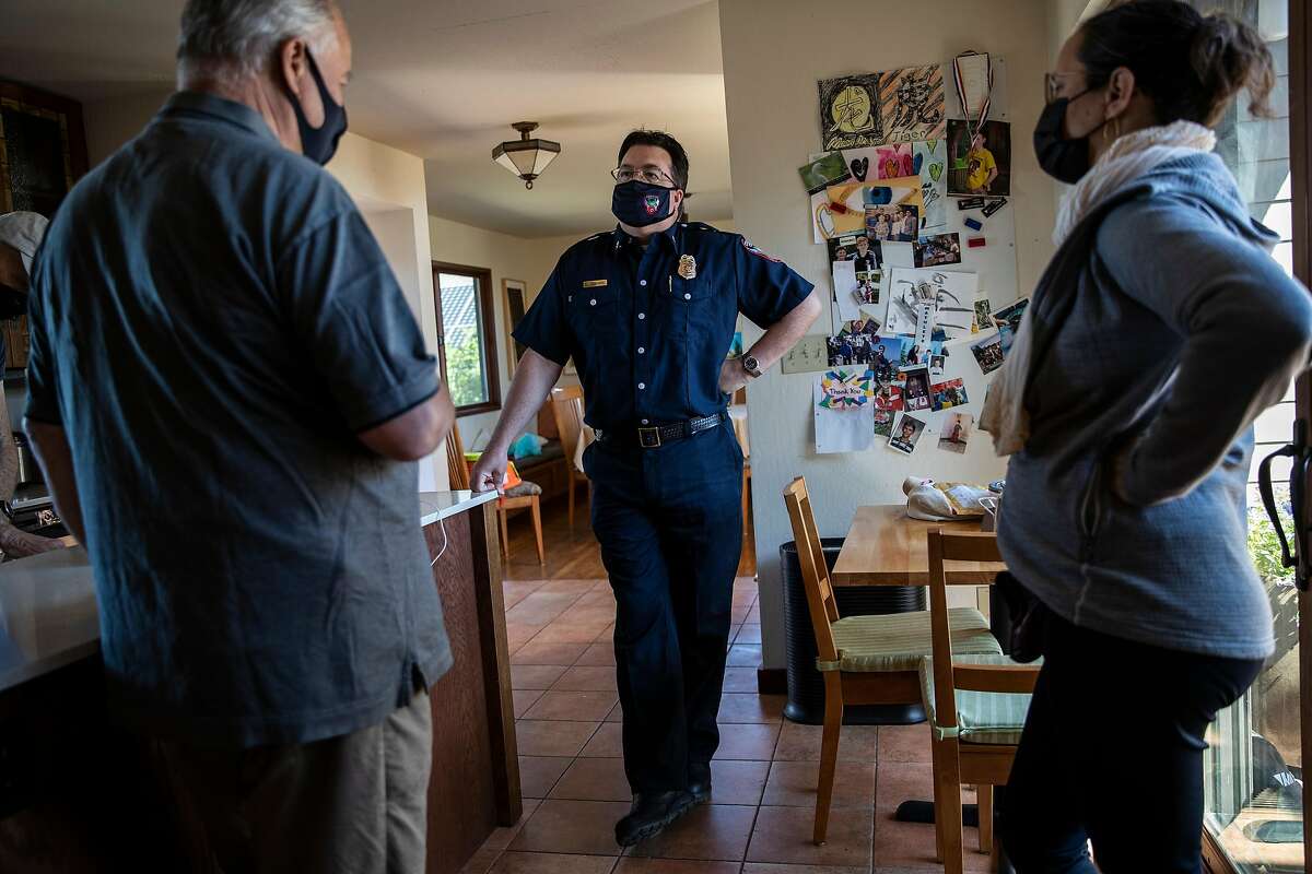 Contra Costa County Fire Protection District Fire Chief Lewis Broschard, center, talks with Wildcat Watch volunteers James Mahshi, left, and Maya Churi, in Kensington, Calif., Tuesday, May 11, 2021.