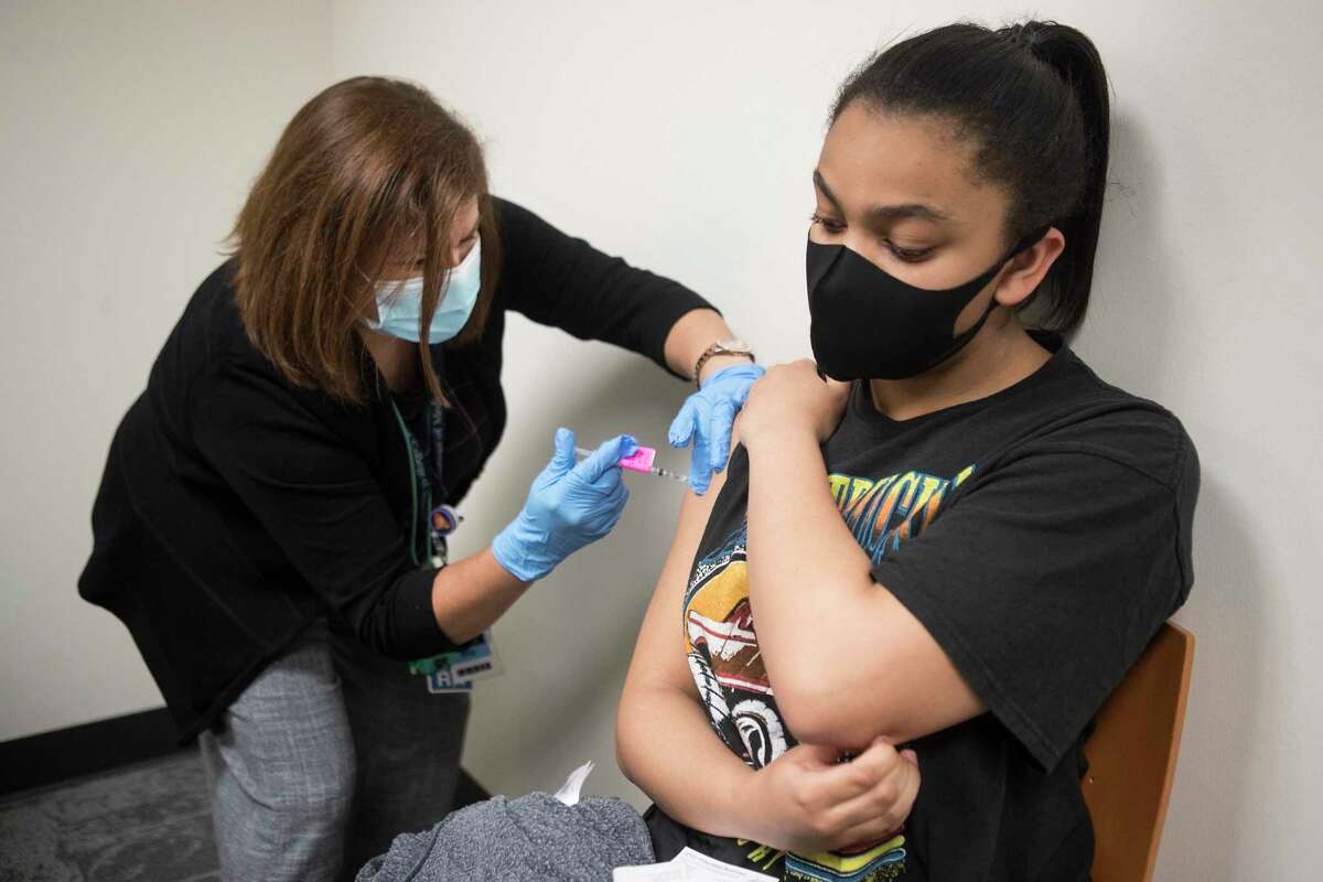 12-year-old Kennedy Gant receives Pfizer BioNTech vaccine from RN Lisa Icard at Baylor College of Medicine Wednesday, May 12, 2021 in Houston.
