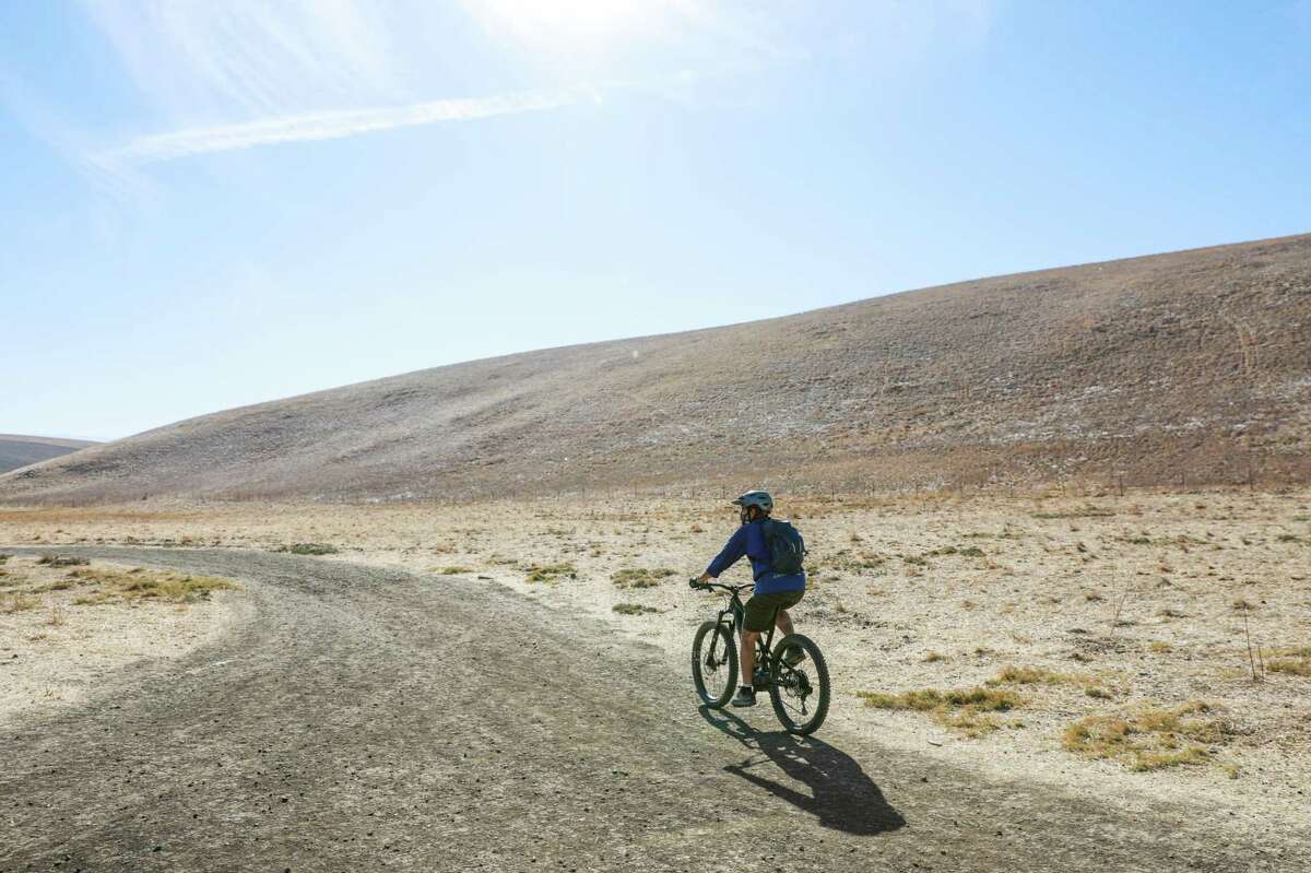 A man bikes on a trail in Brushy Peak Regional Preserve on Monday, Nov. 16, 2020 in Livermore, Calif. Parts of the Bay Area were under a red flag warning, signaling a heightened risk of wildfires starting and spreading.