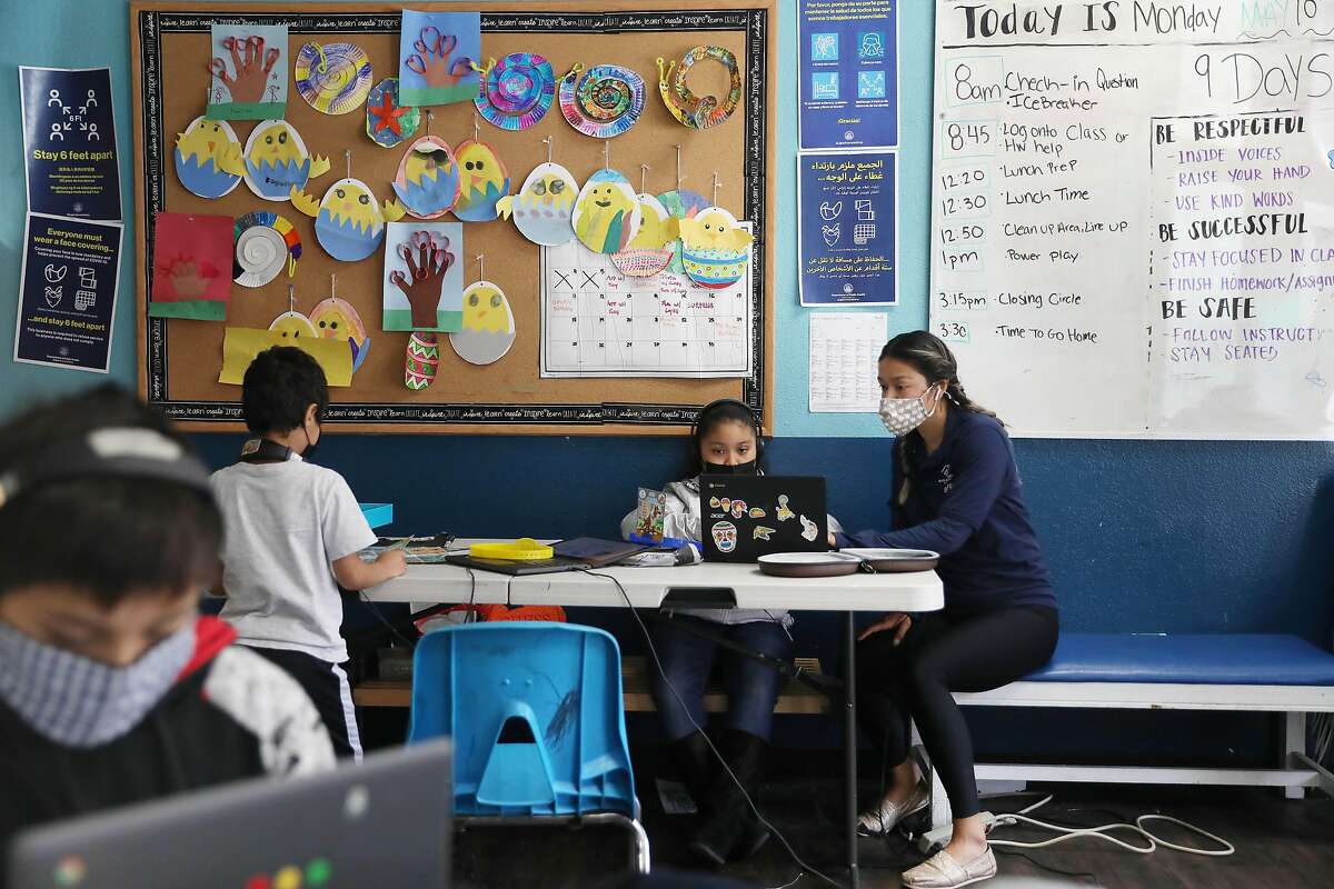 Desiree Almeida (right), health and fitness coordinator, works with Giselle (second from right), 9, at the elementary school learning hub at 201 Turk Street, part of the Tenderloin Clubhouse campus. San Francisco is funding the clubhouse and similar programs over the summer as part of a broader program that uses state funding.
