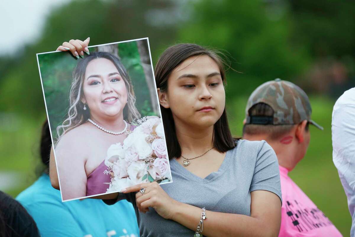 Briza Armenta, the oldest daughter of Erica Hernandez, holds her mother's photo during a press conference at the site where her body was found in a submerged SUV Wednesday, May 12, 2021, in Pearland.