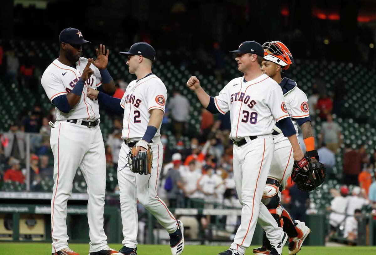 Houston Astros Yordan Alvarez (44), Alex Bregman (2) and relief pitcher Joe Smith (38) celebrate the Astros 9-1 win over the Los Angeles Angels after an MLB baseball game at Minute Maid Park, Wednesday, May 12, 2021, in Houston.